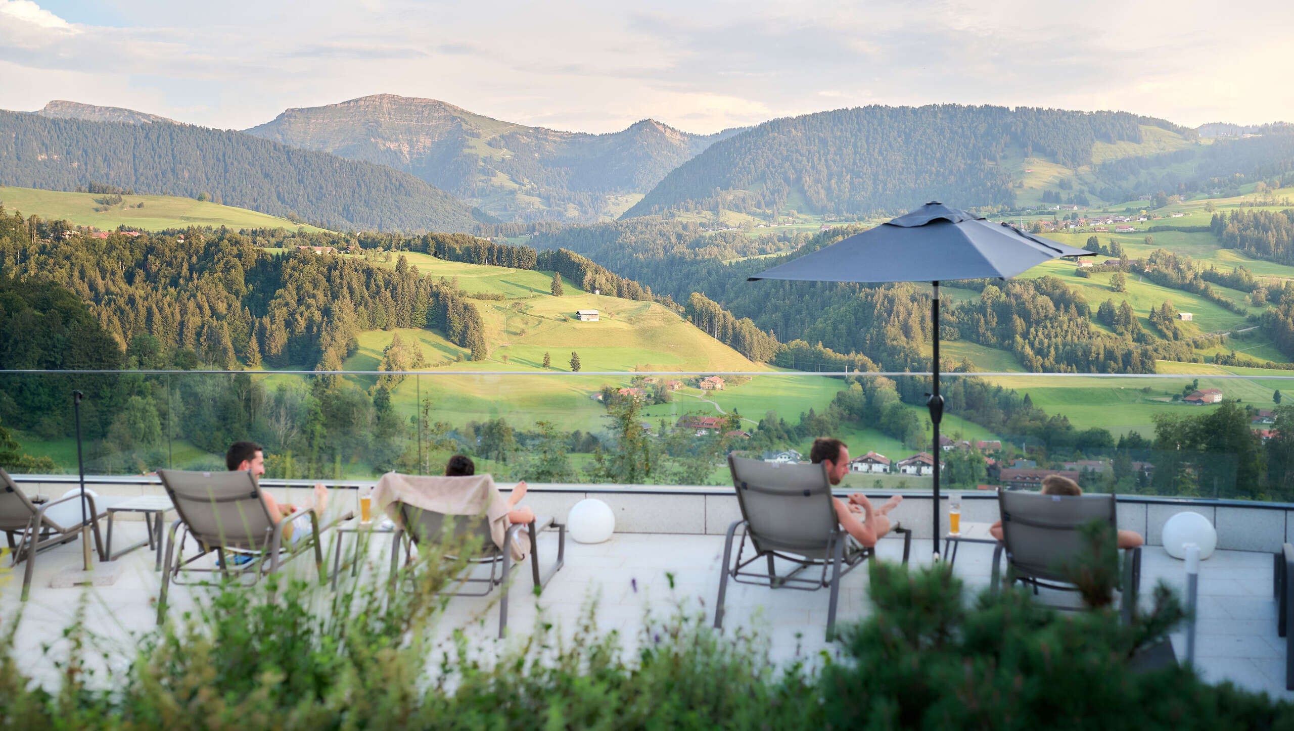 Sonnenterrasse mit Bergpanorama Entspannen auf den Liegen der Sonnenterrasse im Aquaria Außensaunabereich mit Bergpanorama im Sommer